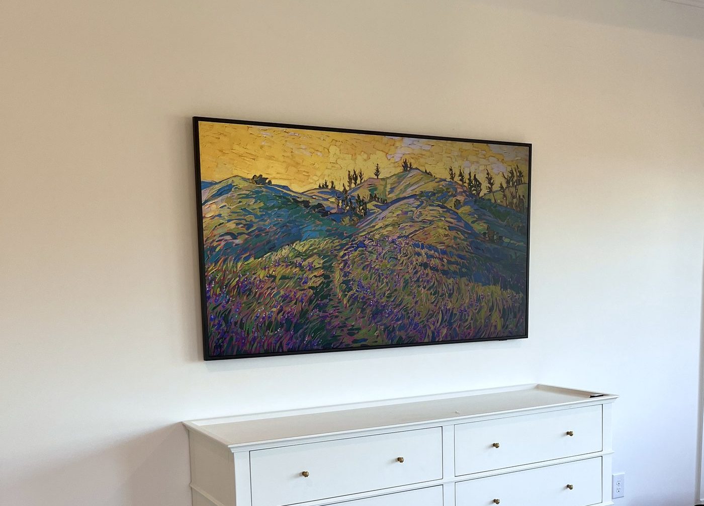 Large framed artwork hung level above a dresser