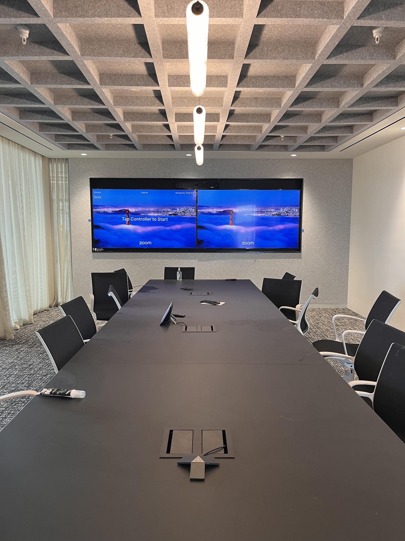 Boardroom with a long conference table and dual wall displays — Argos AV conference room installation