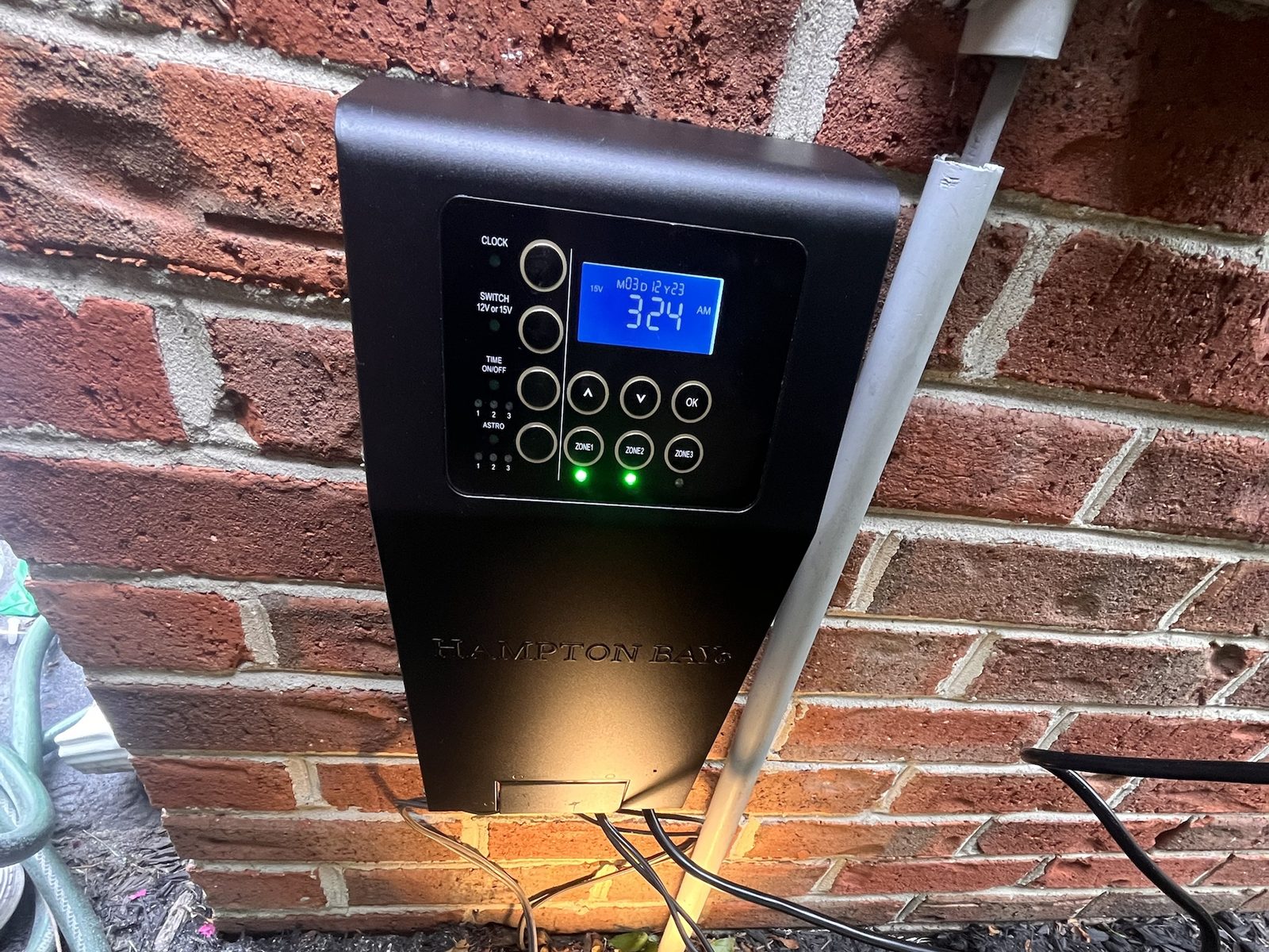 Low-voltage landscape lighting transformer with timer mounted on a brick wall — Argos AV outdoor lighting install