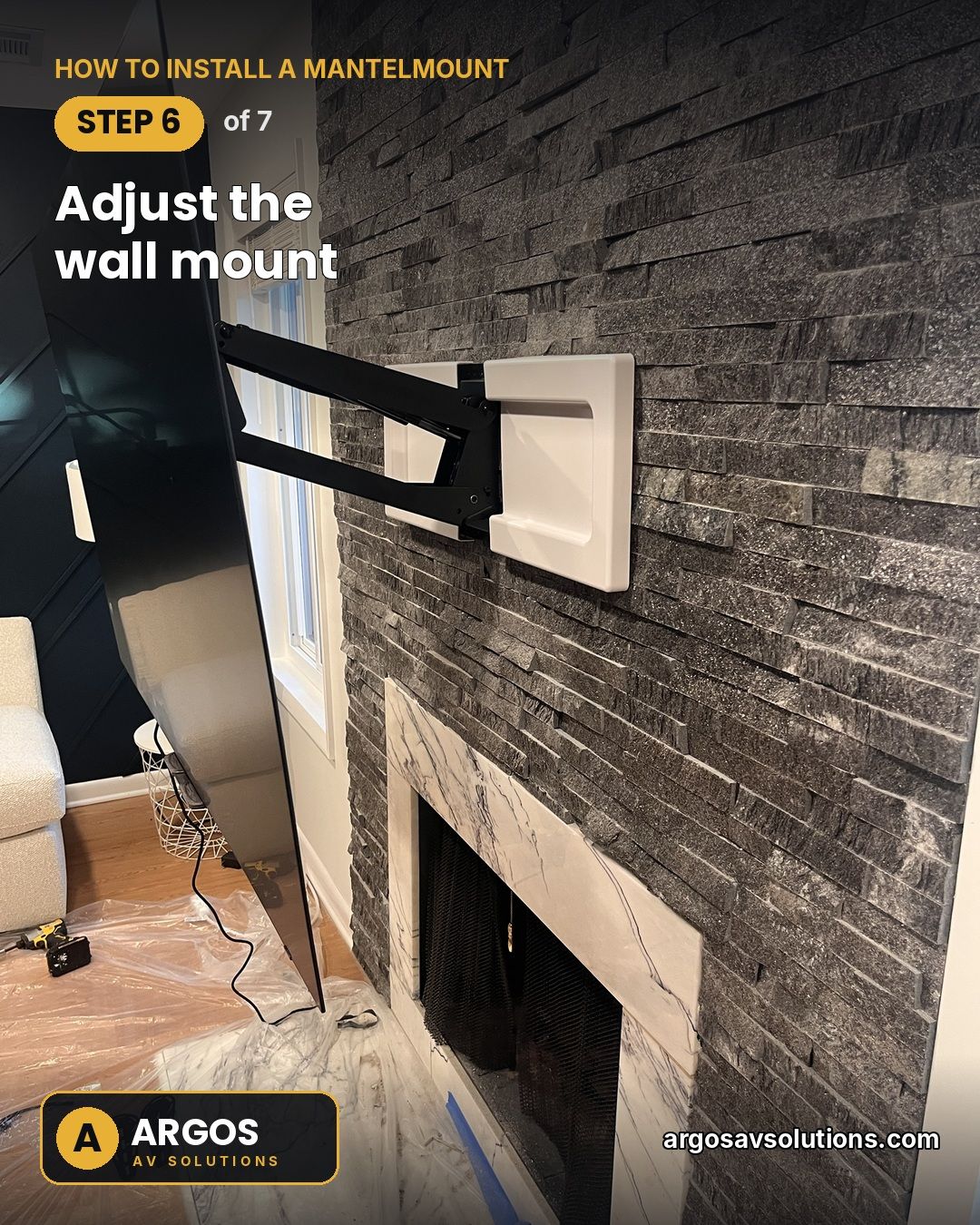 MantelMount arm extended from a stacked-stone fireplace with white wall-plate covers installed and the TV pulled down