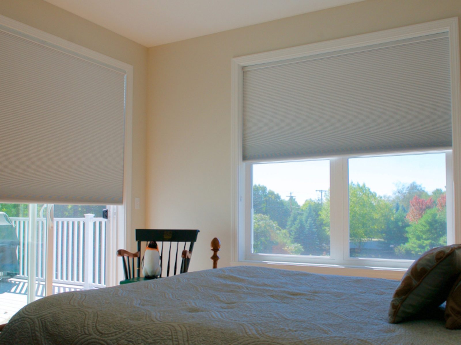 Motorized cellular shades half-lowered on bedroom windows — Argos AV motorized shade install