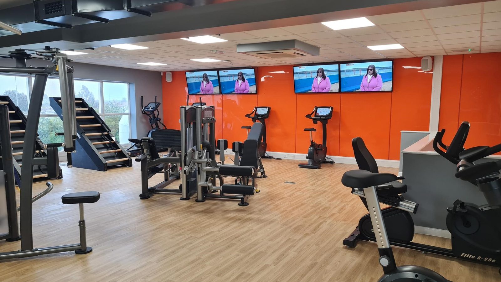 Gym cardio area with a row of wall-mounted TVs and ceiling speakers — Argos AV restaurant, retail and gym audio install