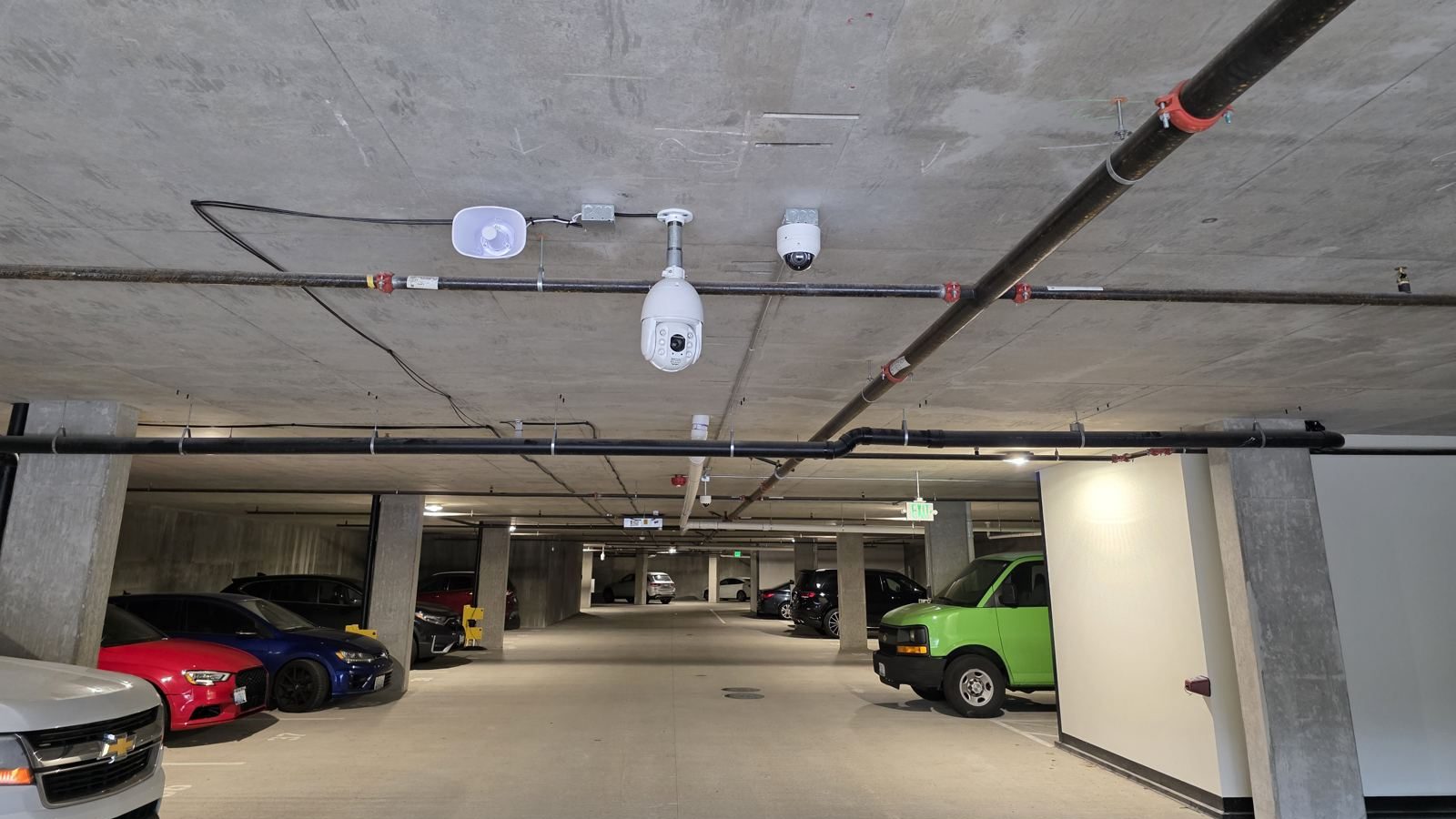 PTZ and dome security cameras with wireless access point mounted on a parking garage ceiling — Argos AV commercial camera and access control install