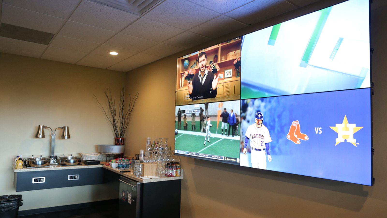 2x2 video wall showing multiple sports feeds in a hospitality suite — Argos AV sports bar and multi-TV video install