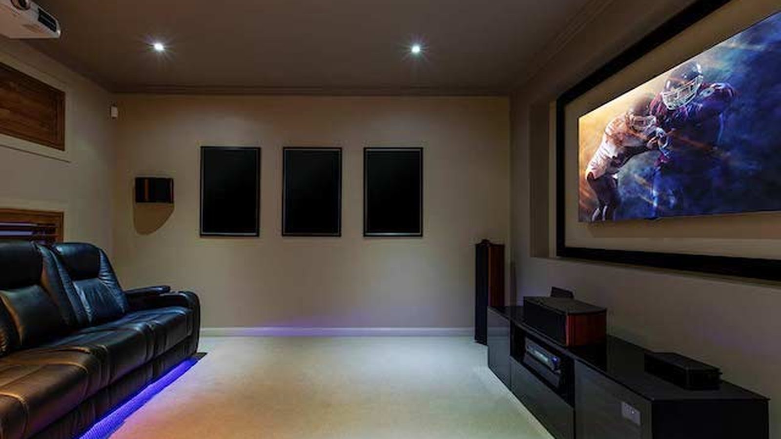 Dedicated home theater with projector, screen, surround speakers and leather recliners — Argos AV home theater installation