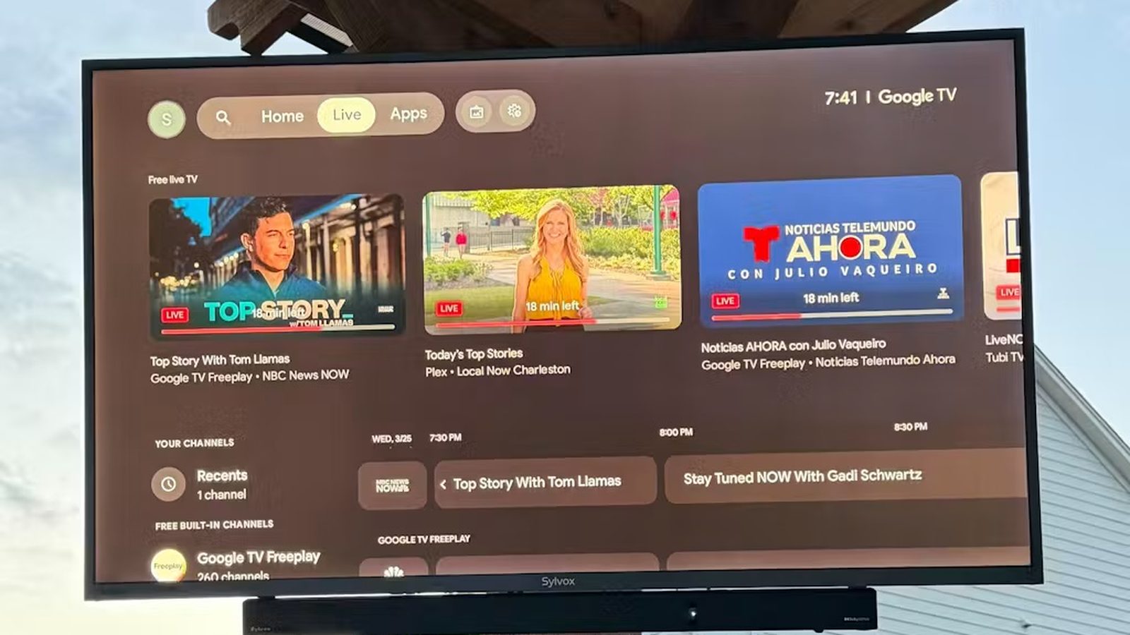 Weatherproof outdoor TV and soundbar mounted on a pergola post at dusk — Argos AV outdoor TV and audio installation