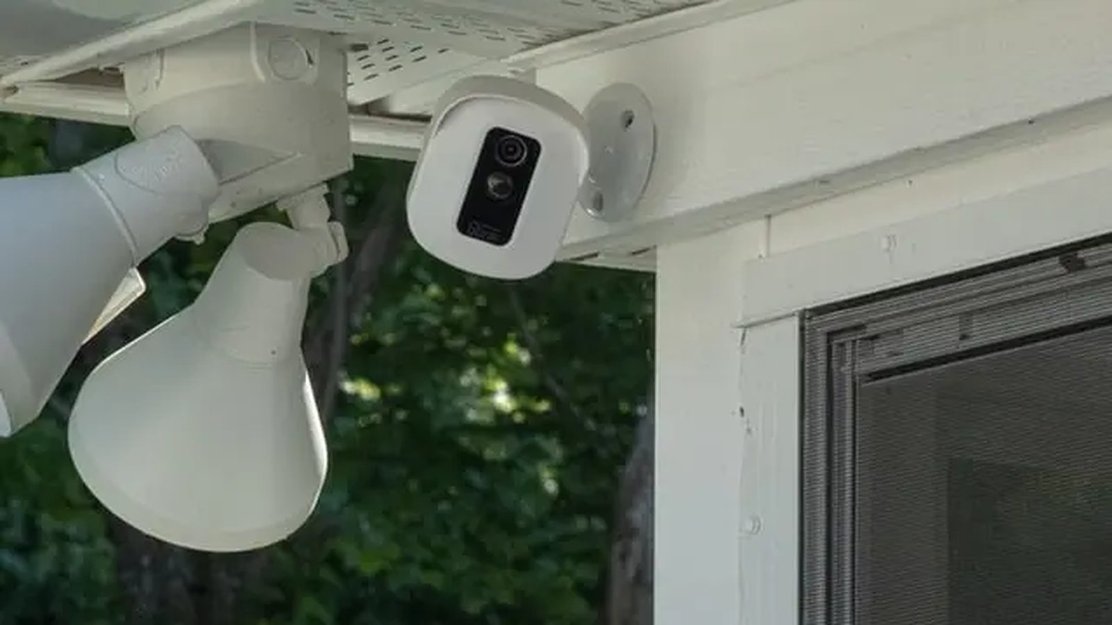 Outdoor security camera and floodlight mounted under the eave of a home — Argos AV security camera installation