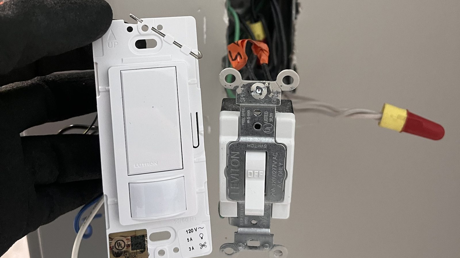 Technician swapping a standard Leviton switch for a Lutron smart switch — Argos AV smart switch and dimmer install