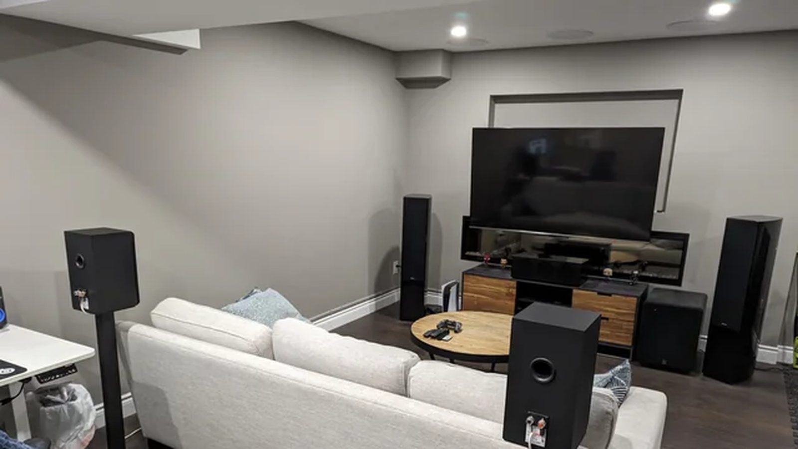 Basement media room with tower speakers, surround speakers and a large TV — Argos AV install