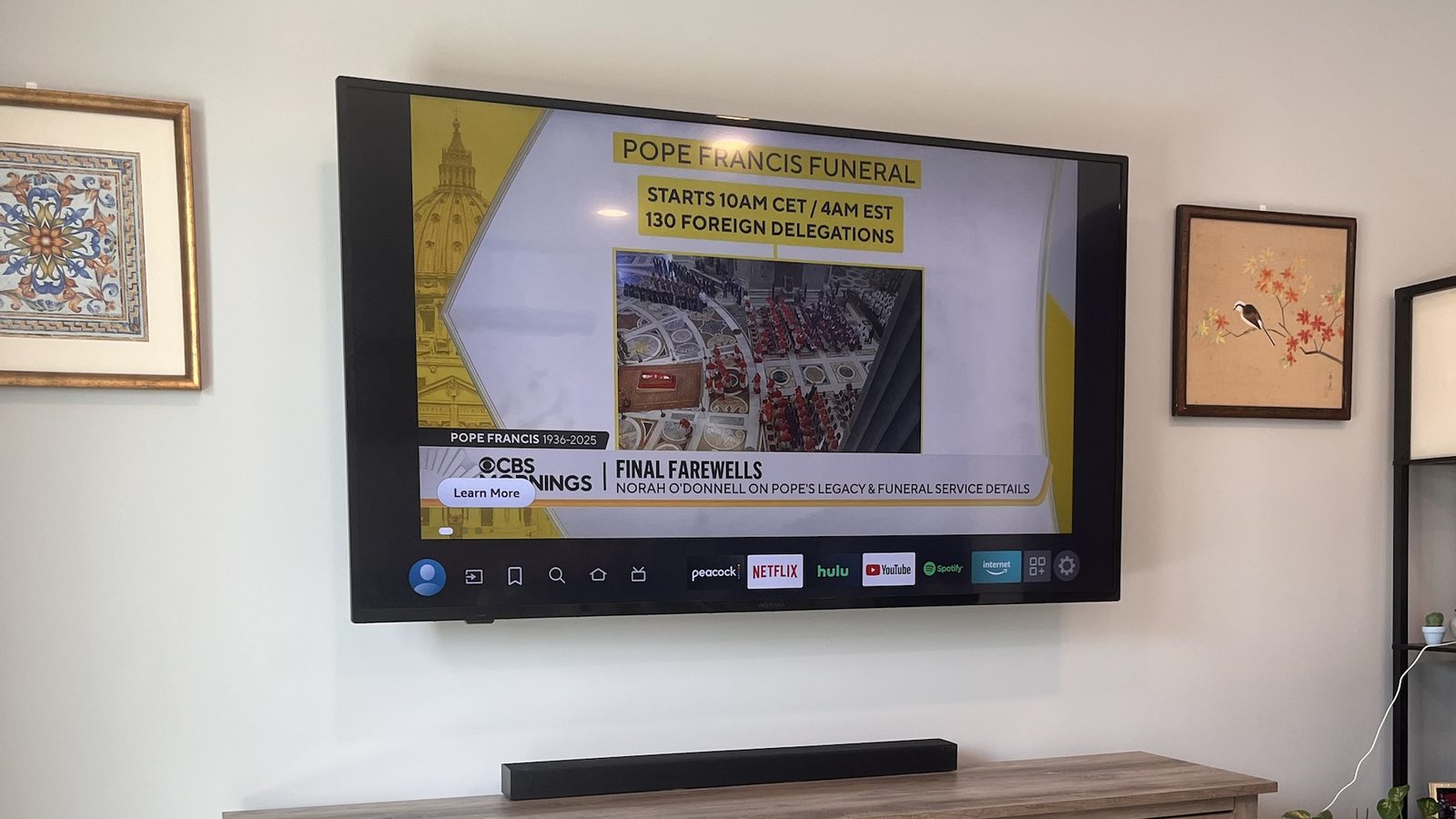 Large TV wall-mounted above a media console with soundbar, cables hidden in the wall — Argos AV TV mounting install