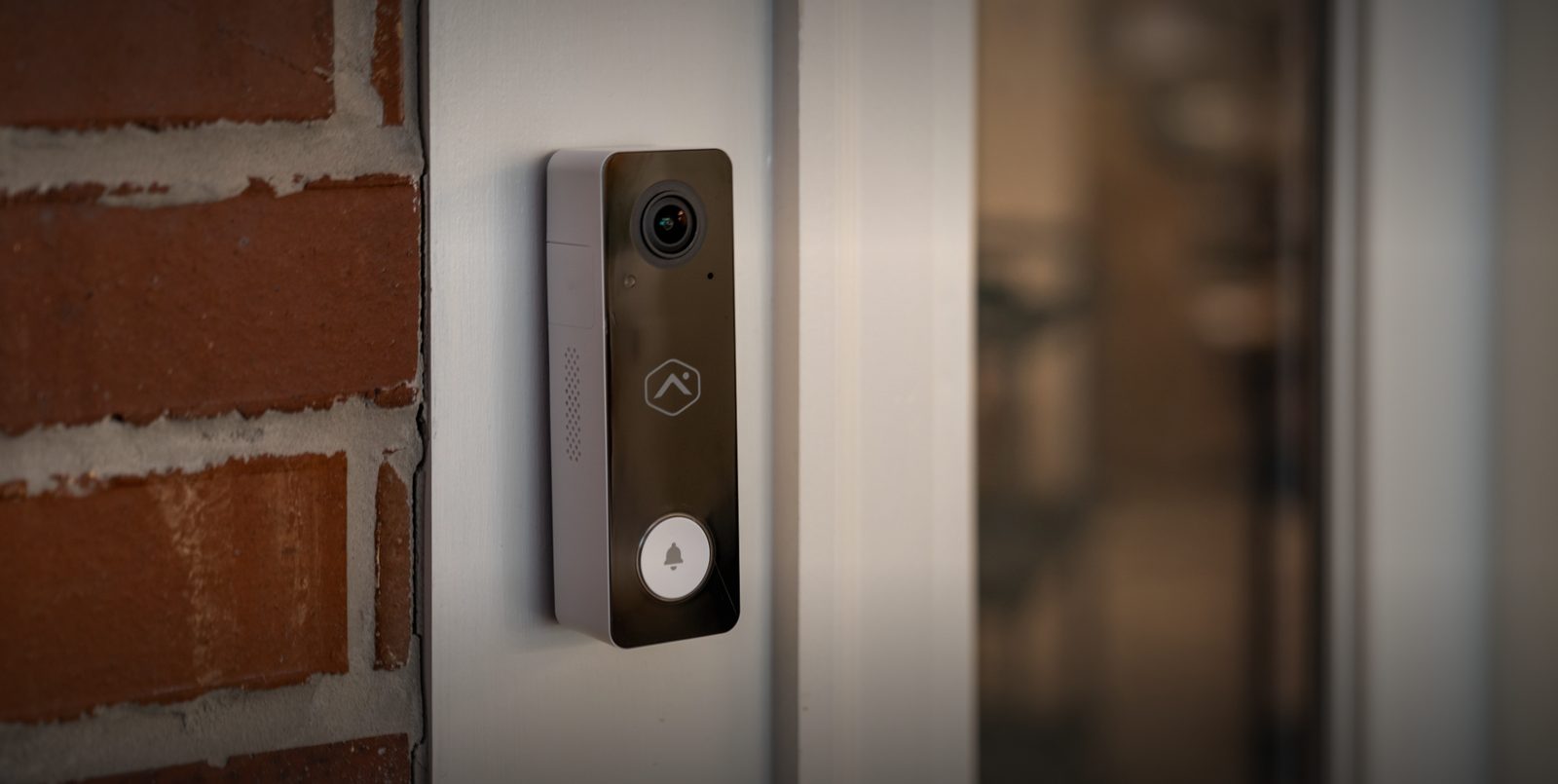 Video doorbell installed beside a front door on brick — Argos AV doorbell and security camera installation